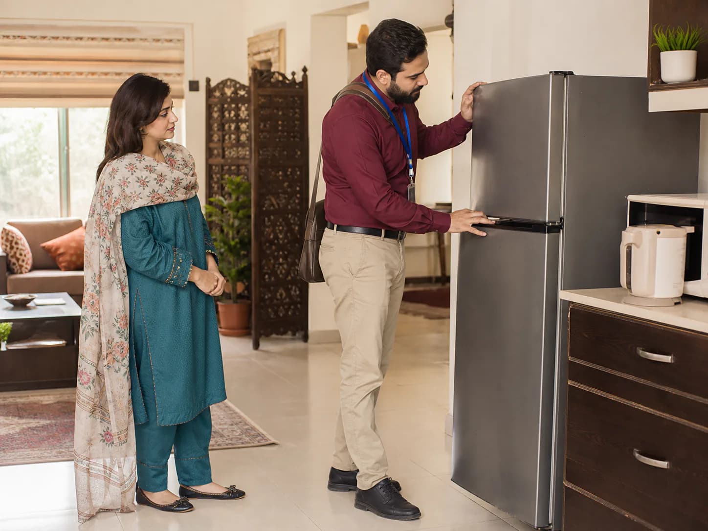 A local dealer inspecting a used refrigerator during a home visit
